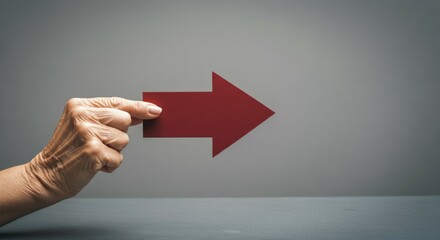 Elderly caucasian female hand pointing red arrow on grey background