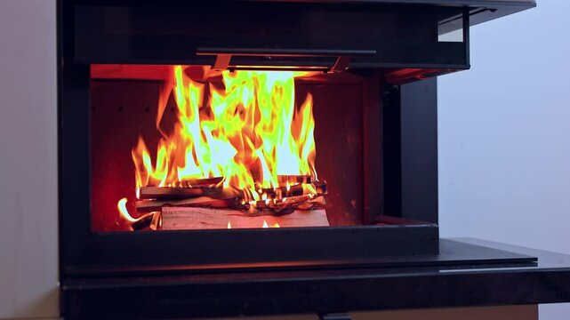 Bright flames dancing in modern fireplace, emitting warmth and creating cozy ambiance in room. Sweden.