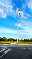 Ukrainian flag flying high in a city park under a clear blue sky during daylight