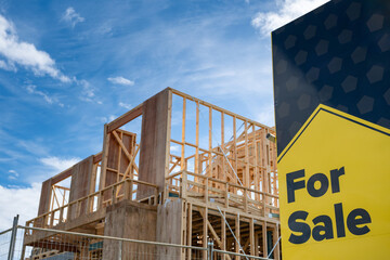 The advertisement sign of ‘for sale’ with a blurry background of a suburban house under...