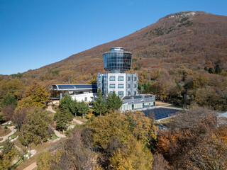 A drone view of Teleferic Dajti Express set against a lush, forested mountain landscape under a...