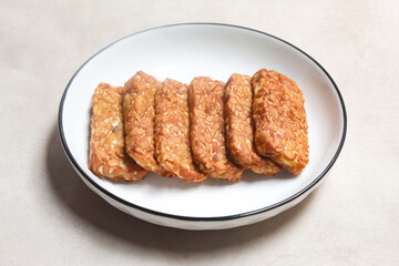 pieces of fried tempeh, made from soybeans, served on a plate.