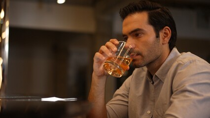 Sitting smart man drinking alone of cocktail Old fashioned waiting friends or couple at bokeh lighting at luxurious beverage counter nightclub at pub and restaurant on Friday meeting night. Vinosity.