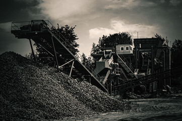 Crushing machinery, cone type rock crusher, conveying crushed granite gravel stone in a quarry open...