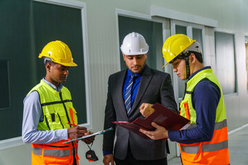 Construction project meeting with workers discussing plans in a modern facility during daylight hours
