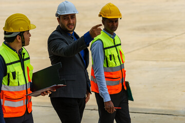 Construction project meeting with workers discussing plans in a modern facility during daylight hours