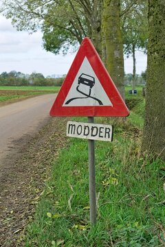 Warning sign with image of slippery car and a sign below that says "mud". (translation modder = mud)