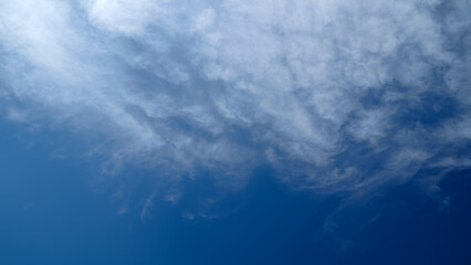 A blue sky with clouds. The clouds are white and fluffy. The sky is clear and bright