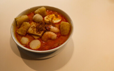 close up of Singaporean Malaysian soup laksa noodles with fishballs, tofu bean curd, prawns, shrimps and fish slice