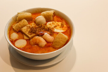 close up of Singaporean Malaysian soup laksa noodles with fishballs, tofu bean curd, prawns, shrimps and fish slice