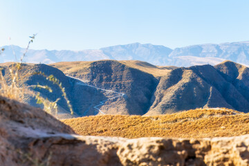 A scenic view of a rugged valley framed by arid terrain and desert vegetation and the majestic...