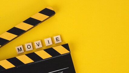 clapper board and scramble word movie on yellow background