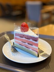 A delectable slice of cake with rich layers of cream and frosting, topped with fresh fruit or sprinkles. Perfect for dessert photography, showcasing indulgence and sweetness in food-related projects.
