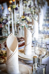 Wedding table decoration with flowers and candles. The elegant wedding table for guests. Stylish table set for wedding dinner