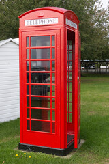 Obraz premium British red telephone box with door slightly open.