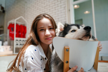 Woman holding a small Shetland Sheepdog with a kitten, showing love and affection for their pet