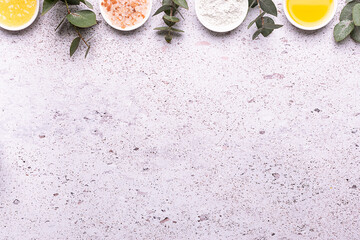 Set of organic eco skin care products in white unbranded containers , beautiful flowers and eucalyptus leaves on marble background top view.
