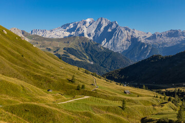 Obraz premium Marmolada peak, the highest mountain in the Dolomites. The rocky wall of Marmolada summit in Dolomiti Alps. The green valley and glacier of Marmolada top