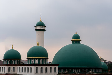 Obraz premium Mosque with a green dome in indonesia on cloudy sky