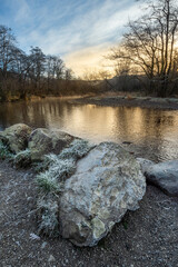 Beautiful dramatic Winter morning landscape image of frozen River Rathay in Lake District