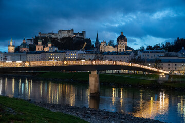 Salzburg Austria at night - love padlocks placed by couples on a fence of the Makartsteg (Makart's bridge) illuminated at night by Christmas lights along Salzach River