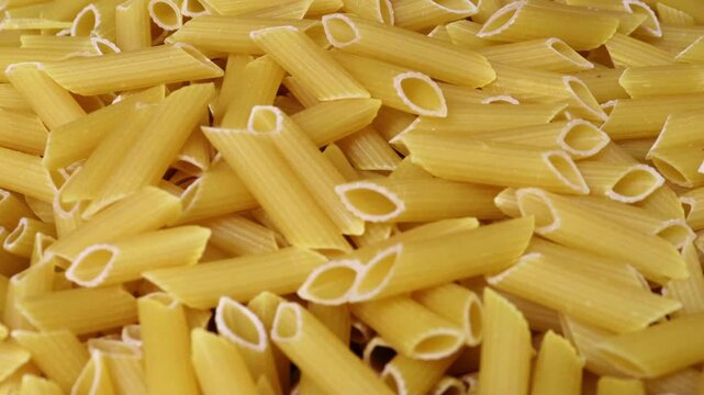 Close-up view of pasta. Raw Italian pipe-shaped pasta 4k footage. 
