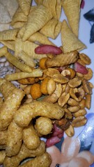 Fototapeta premium Très belle assiette d'apéritifs composé de biscuits avec frites, tuiles et cornets, maïs, gâteaux de riz, grains, cacahuètes soufflées
