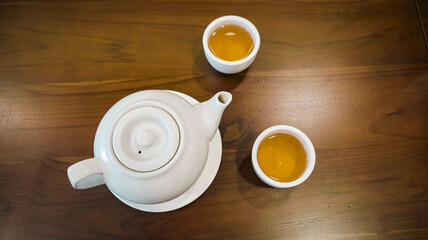 A teapot and tea cup made of white ceramic.