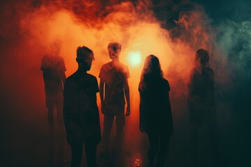Five silhouettes are shrouded in colorful smoke at night, creating an eerie yet intriguing ambiance as they stand silently together in a mystical setting.