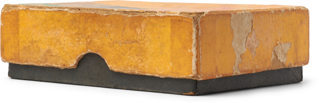 close-up of old and worn out small rectangular cardboard box with yellow lid and black base, faded with uneven discoloration with damage and frayed edges