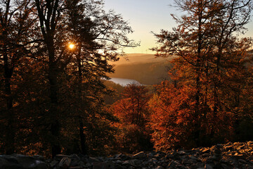 Der Stausee Nonnweiler während des Sonnenuntergangs in malerischer Natur im Herbst im Nationalpark Hunsrück-Hochwald. Aussicht von den Premium-Wanderwegen Dollbergschleife und Saar-Hunsrück-Steig.
