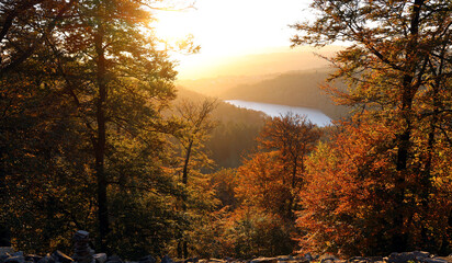 Obraz premium Der Stausee Nonnweiler während des Sonnenuntergangs in malerischer Natur im Herbst im Nationalpark Hunsrück-Hochwald. Aussicht von den Premium-Wanderwegen Dollbergschleife und Saar-Hunsrück-Steig.