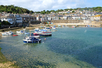 Fototapeta premium Mousehole fishing village harbour, at low tide, on the shore of Mount's Bay, Cornwall, UK.
