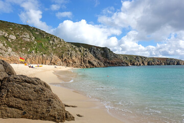 Sandy Porthcurno Beach, with Logan Rock headland, West Cornwall, UK.