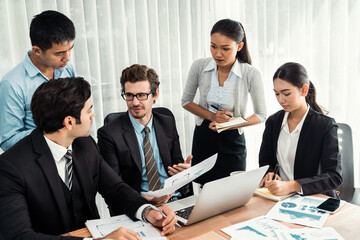 Diverse of business people from various ethnic group working in modern office environment. Productive and multi ethnic office workers engage in discussion for strategic business marketing. Meticulous