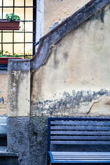 old wall with windows and a bench