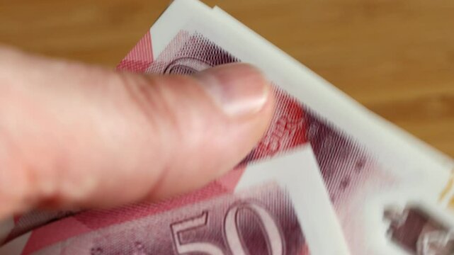 UK money. british pounds slowly counted in fingers. GBP Currency, Financial concept, close-up