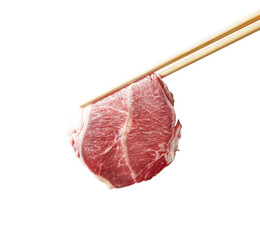 Thinly sliced raw beef held by wooden chopsticks against a white background, showcasing its marbled...