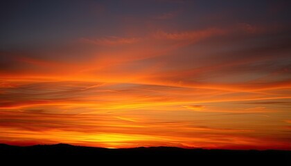 Obraz premium Fiery Sunset Over Silhouetted Mountains: A Canvas of Orange and Red Hues