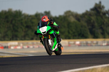 rider on a green sport bike riding fast on a straight 