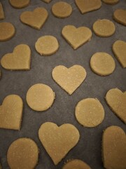 Obraz premium Heart and circle shaped cookies baking on parchment paper for valentine's day