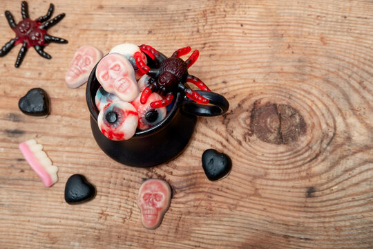 marmalade in the shape of an apple, heart and skull in a black mug on a wooden background. Halloween flatley