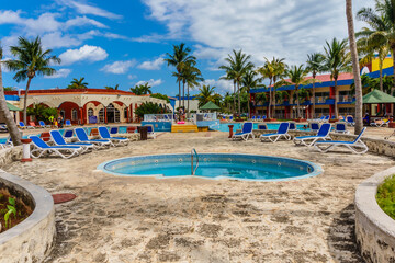 A beach resort with a pool and lounge chairs
