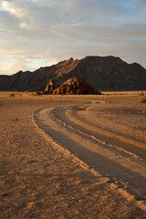 Winding road through the desert at dusk with mountains during a guided trek in Sossusvlei, Namibia