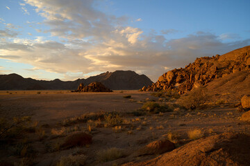 Amazing sunset in the Namibian desert near Sesriem with magnificent clouds and mountains in the background .