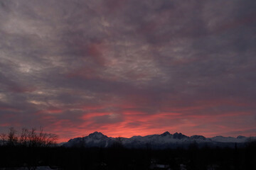 Winter sunrises over Alaska's Chugach Range are often colorful spectacles of sunlight and clouds.