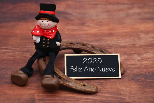 Tarjeta de felicitaci&oacute;n con amuletos de la suerte: deshollinadores y herraduras con el texto Feliz A&ntilde;o Nuevo 2025.