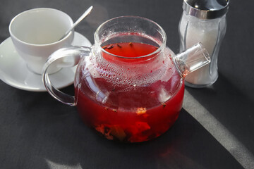 Red hot fruit tea brewed in a glass teapot