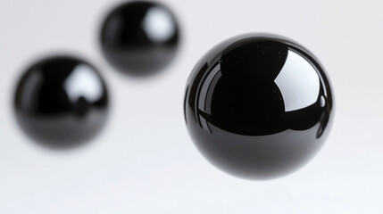Floating black spheres in a minimalistic setting showcasing glossy reflections and smooth surfaces