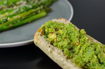 Avocado Toast on a bread roll, sprinkled with dried chili
